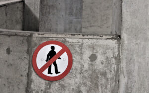 "Fotgjengere forbudt"-skilt på betongvegg.